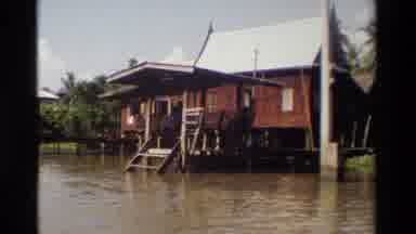 Thailand (1984): Person Riding In Boat In Flooded Village On A Sunny Day