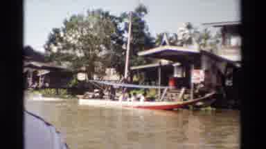 Thailand (1984): People Sailing In Small Wooden Boat Holding Umbrella Clear Sky