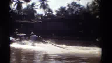 Thailand (1984): Fast Speed Boat Passes Floating Houses Built On The Riverbanks