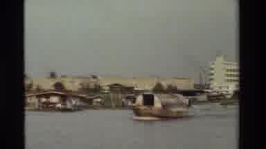 Thailand (1984): Large Boat Like Machine Traveling Along Calm Waters Beside