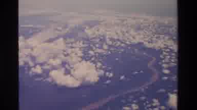 Thailand (1984): Aeroplane Window Shot Of River Under A White Cloudy Sky Below