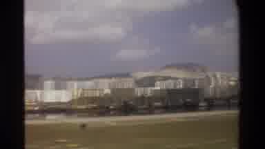 Thailand (1984): Passing View Of White Buildings And Mountain On A Cloudy Day