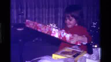 California USA (1979): Girl Picking Out Christmas Presents From Under A Christmas