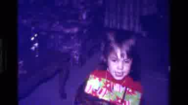 California USA (1979): Child At Christmas Opening Present In Front Of Family