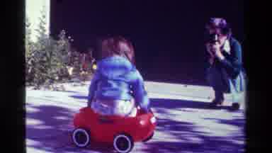California USA (1979): Child In Little Blue Jacket Riding His Tricycle Having Fun