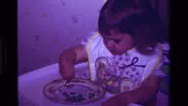 California USA (1979): Baby Eating Blueberries In A High Chair Back Some Years Ago