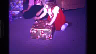 California USA (1979): A Young Girl In A Red Dress Is Opening Presents On