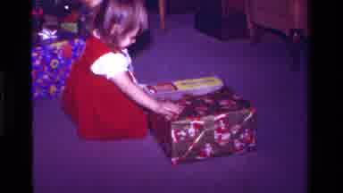 California USA (1979): A Little Girl Unwrapping A Christmastime Present