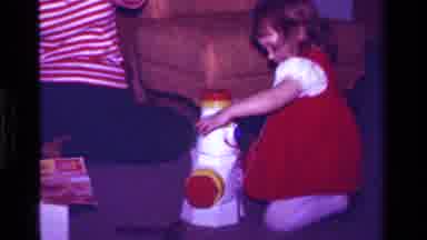 California USA (1979): Toddler Girl In Red Dress Playing On The Carpeted Floor