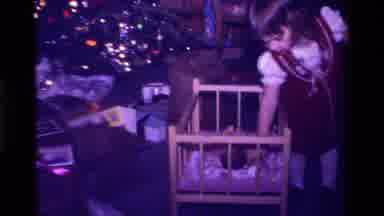 California USA (1979): Little Girl Picking Her Baby Doll Up Out Of The Play Crib