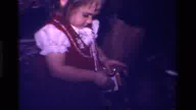 California USA (1979): Little Girl In A Cute Dress Opening A Wrapped Gift