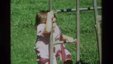 California USA (1979): Little Girl In Pink Dress Climbing Up Her Set Of Monkey