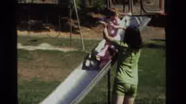 California USA (1979): Mom And Baby Important Playtime Outside On The Park Slide