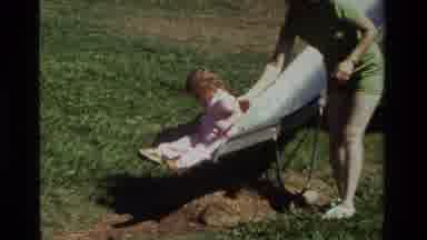 California USA (1979): Little Girl Being Pushed Down Slide By Mother