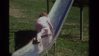 California USA (1979): A Little Girl Trying To Climb Up A Sliding Board