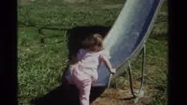 California USA (1979): A Small Child Trying To Go Up On A Slide