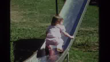 CALIFORNIA USA-1979: A Little Girl Playing On Slide And Swing At Playground