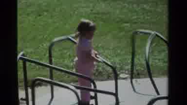 California USA (1979): Little Girl In Pink Clothes Playing In The Merry Go Round