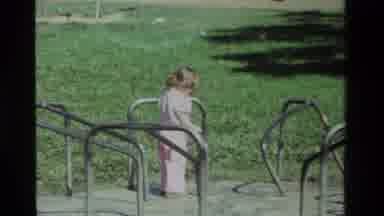 California USA (1979): Girl Rides Around In A Loop On Some Playground Toys