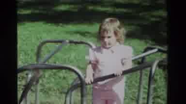 California USA (1979): Little Girl In A Red Dress Having Fun Riding On A Marry Go