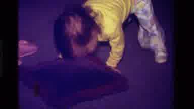 California USA (1979): Baby In Yellow Shirt And Patterned Pants Stands Up And