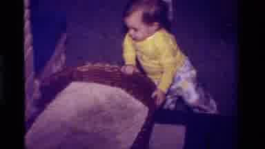 California USA (1979): A Toddler Is Trying To Stand Up By Using The Basket