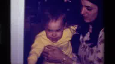 California USA (1979): Mom Holds Baby In A Holiday Birthday Party During 1973