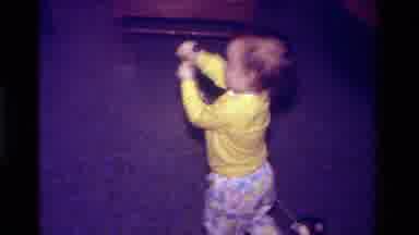 California USA (1979): Young Child In A Yellow Shirt Pulling A Toy With A String
