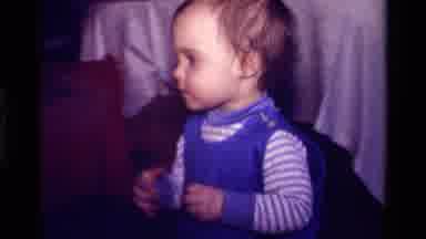 California USA (1979): Little Baby In Overalls Playing With A Ring Stack Game
