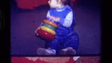 California USA (1979): A Cute Baby Boy Playing With His Toy And Looking Around