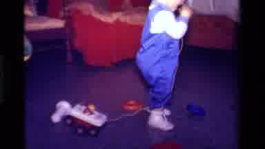 California USA (1979): A Toddler In A Room Pulling A Toy Car On A String
