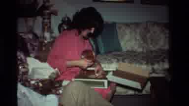 California USA (1981): A Mother And A Little Girl Opening Christmas Presents And