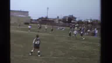 California USA (1981): Little Girls Playing Soccer On Soccer Field While Families