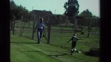 California USA (1981): A Man Taking Pictures Of A Young Boy Playing Soccer