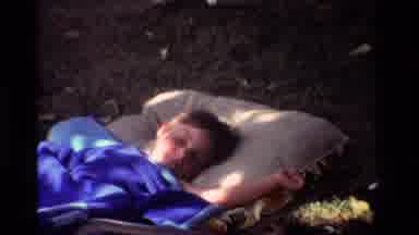 California USA (1981): A Young Child Is Sleeping In A Sleeping Bag Outside When