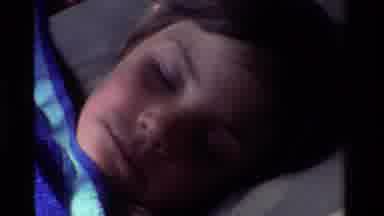 California USA (1981): A Child Is Sleeping Soundly In A Sleeping Bag Outside With