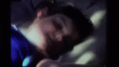 California USA (1981): Child In Blue Shirt Smiling And Rolling Around In Bed