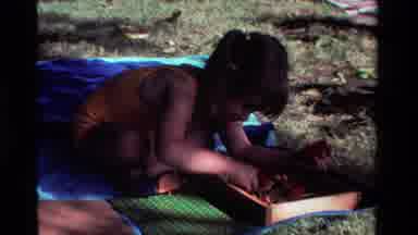 California USA (1981): A Boy Playing With Toys Alone Under The Shadow Of A Tree