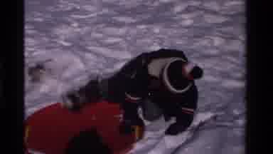 California USA (1981): Winter Time Snow Day Sledding On Snow Mounds With Red Sleds