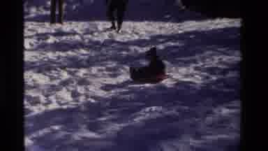 California USA (1981): Small In Hat Sledding Down A Hill On Tray Or Disk