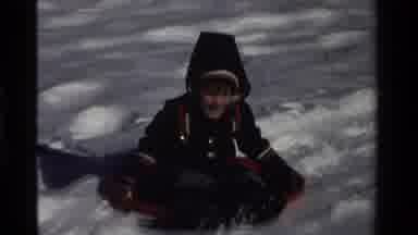 California USA (1981): A White Snowy Hillside With Kids Sledding Down-Hill
