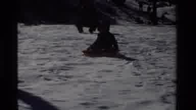 California USA (1981): A Child Bundled Warmly In Winter Wear Slides On A Snow