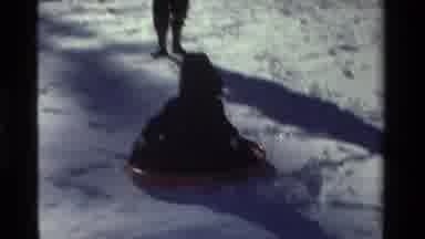California USA (1981): Adult And Child Sledding Down A Small Snow Covered Hill