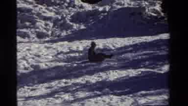 California USA (1981): Classic Childhood Fun Sledding Down A Snowy Hill In Winter