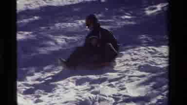 California USA (1981): Adult And Child In A Saucer Sledge In The Snow Preparing To