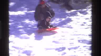 California USA (1981): A Little Boy Having Fun Sledding And Skiing With His Family