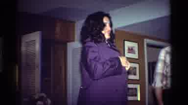 California USA (1984): Dark Haired Woman Tries On A New Shirt; Bearded Man Holds A