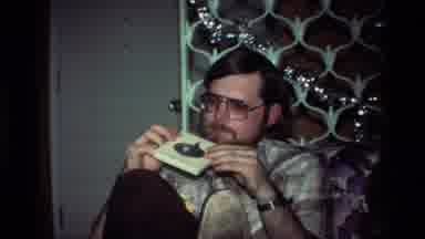 California USA (1984): Man Sitting In A Chair And Looking At A Old Cd And