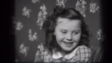 New York USA (1939): Bashful Little Girl Smiles At The Camera Before Breaking Out