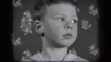 New York USA (1939): A Boy Standing In Front Of A Wall Laughs Showing His Teeth